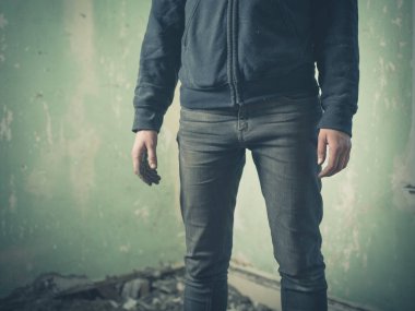 Bir gizemli ve korkunç görünümlü ve biraz ürkütücü görünümlü kişi terk edilmiş bir odada duruyor