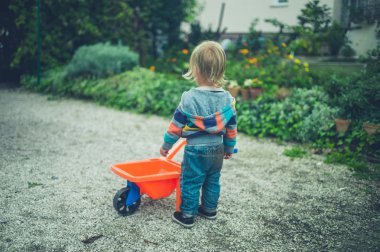 Küçük bir bebek bir oyuncak el arabası ile oynuyor