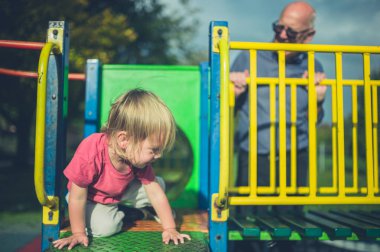Bir yürümeye başlayan çocuk parkında dedesi ile eğlenceli olması