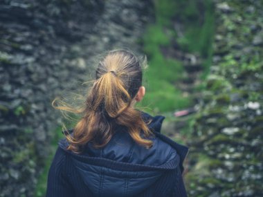 Genç bir kadın, yosun kaplı kaya dağlarda arıyor