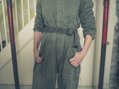 Bir kazan takım elbise giymiş bir kişi yenileme geçiren bir odada duruyor