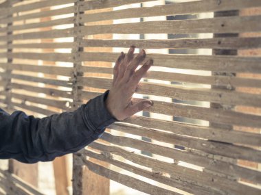 Bir genç kişi el wattle and daub duvar eski dokunuyor