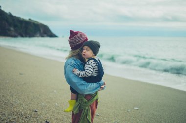 Bir anne ve yürümeye başlayan çocuk sahilde sonbaharda rahatlatıcı