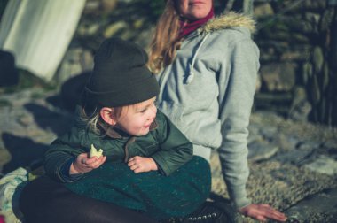 Açık havada annesinin kucağında küçük bir toddler yalan söylüyor