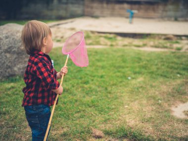 Küçük bir yürümeye başlayan bir net holding bir oyun alanında duruyor