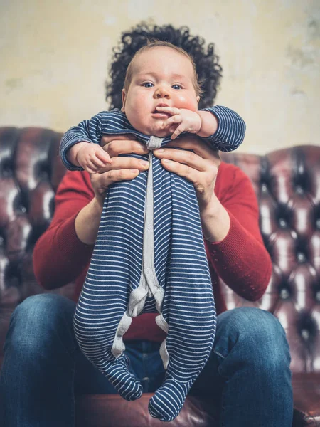 Jovem Pai Está Sentado Sofá Com Seu Bebê Pequeno — Fotografia de Stock