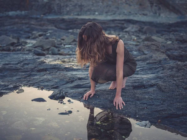 Młoda Kobieta Siedzi Przy Basenie Rock Wybrzeżu Zachodzie Słońca — Zdjęcie stockowe