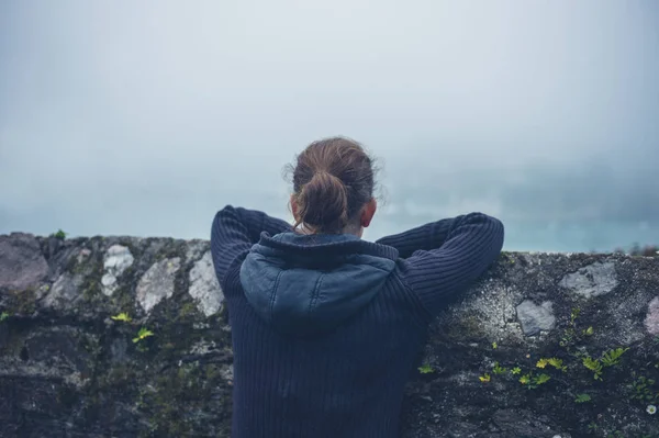 Una Joven Está Descansando Una Pared Afuera Niebla — Foto de Stock