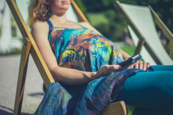 Беременная Женщина Отдыхает Шезлонге Пользуется Смартфоном — стоковое фото