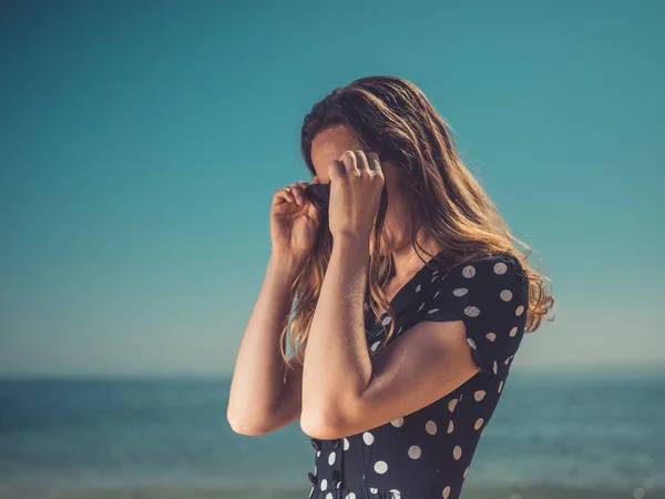 海滩上一个性感的年轻女子正在戴上她的太阳镜 — 图库照片
