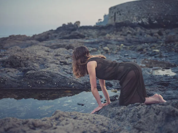 Młoda Kobieta Siedzi Przy Basenie Rock Wybrzeżu Zachodzie Słońca — Zdjęcie stockowe
