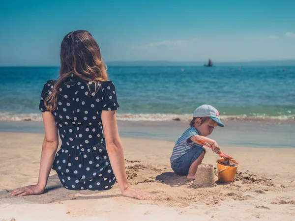 Una Joven Madre Está Jugando Con Hijo Playa Construyendo Castillos — Foto de Stock