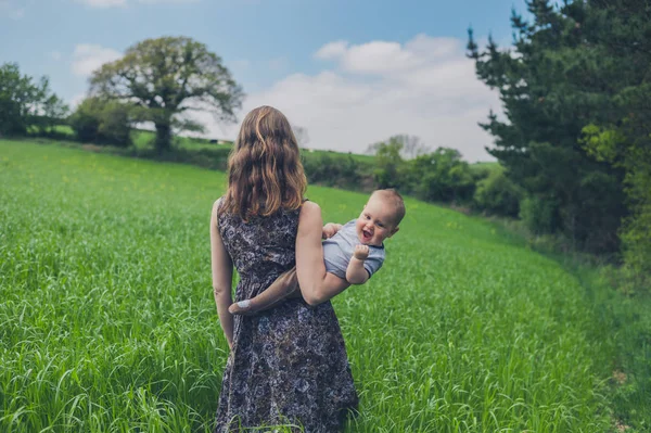 Bebê Feliz Sendo Segurado Por Sua Mãe Campo Está Fazendo — Fotografia de Stock