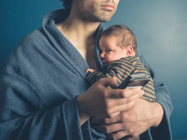 Padre Joven Está Usando Teléfono Inteligente Mientras Sostiene Hijo Bebé —  Fotos de Stock