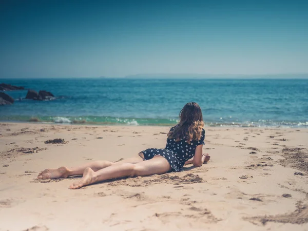 Μια Όμορφη Νεαρή Γυναίκα Είναι Χαλαρώνοντας Στην Παραλία — Φωτογραφία Αρχείου