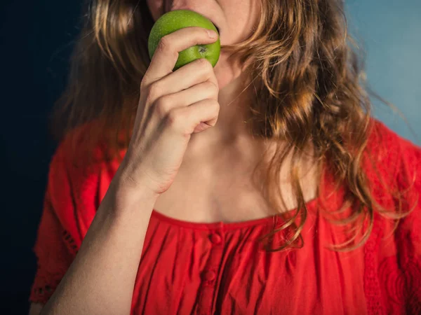 Kırmızı Elbiseli Bir Genç Bir Kadın Elma Yiyor — Stok fotoğraf