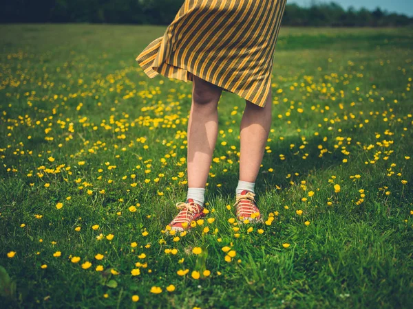 一个年轻女子拿着站在草地上 用脚和腿的形象 — 图库照片