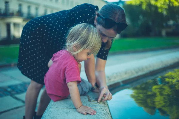 Una Joven Está Jugando Con Niño Cerca Una Fuente Parque — Foto de Stock