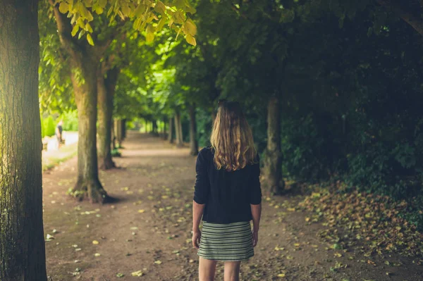 一个年轻的女人正在公园里散步 — 图库照片