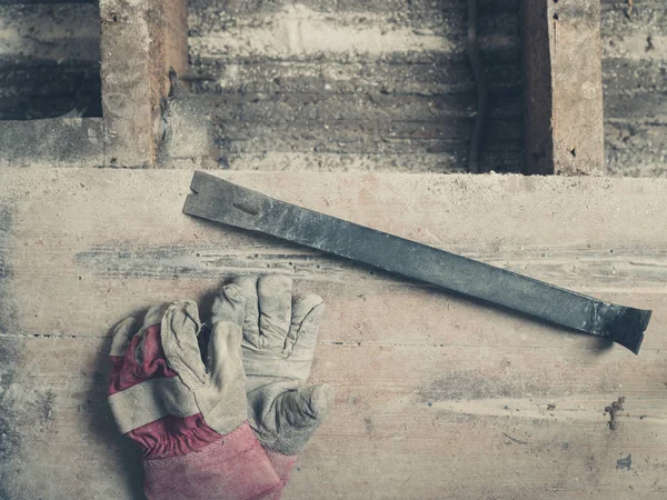 Ein Paar Bauhandschuhe Und Ein Brecheisen Auf Einem Holzboden — Stockfoto