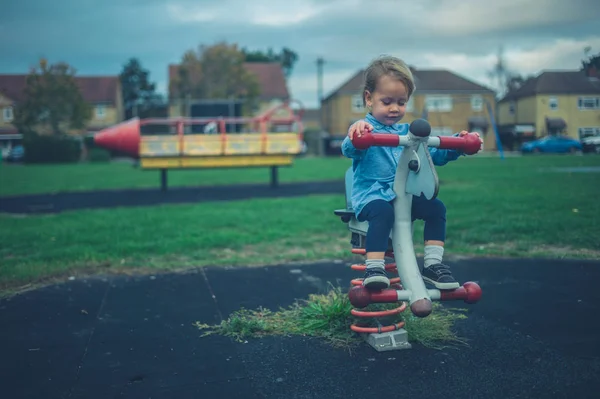 Een Kleine Peuter Zit Speeltoestellen Een Speeltuin — Stockfoto