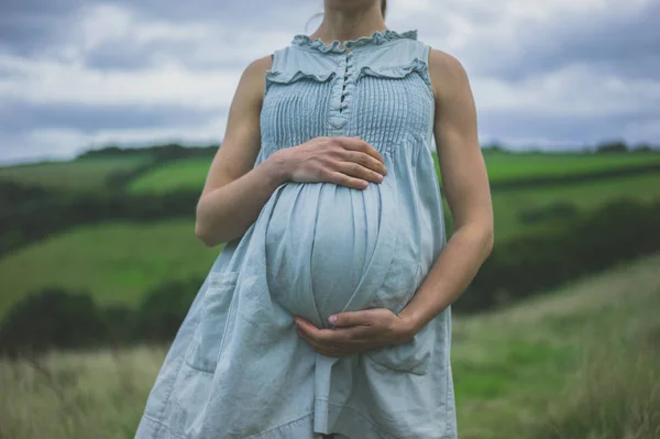 Hamile Bir Kadın Onun Bebek Carpma Tutan Kırsal Kesimde Duruyor — Stok fotoğraf