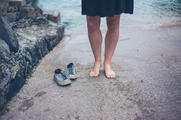 一个赤脚的女人穿着鞋子站在滑道上 — 图库照片