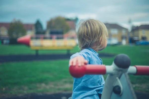 Een Kleine Peuter Zit Speeltoestellen Een Speeltuin — Stockfoto