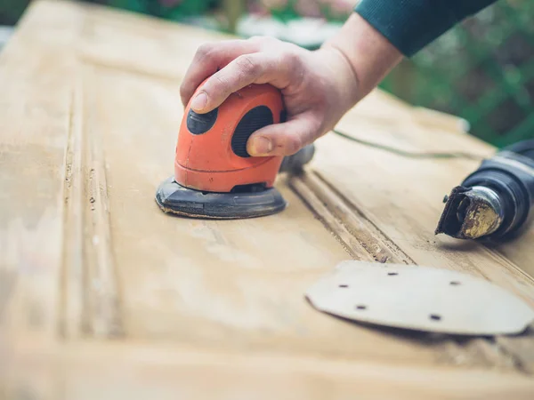 Ung Man Slipning Gammal Dörr Med Elektrisk Slipmaskin — Stockfoto