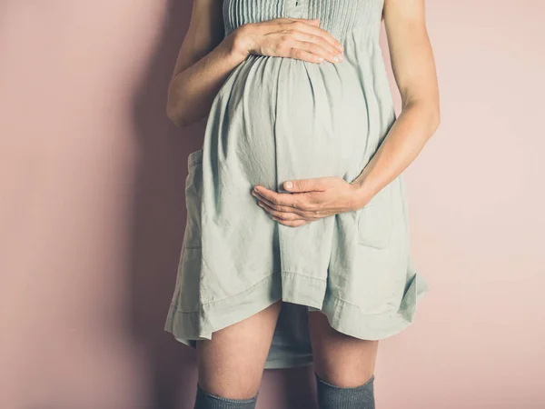 Uma Jovem Grávida Contra Fundo Rosa — Fotografia de Stock