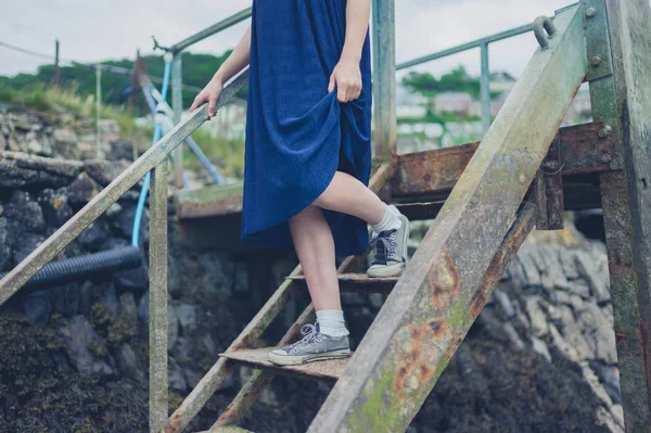 Una Joven Está Bajando Unas Escaleras Oxidadas Afuera —  Fotos de Stock