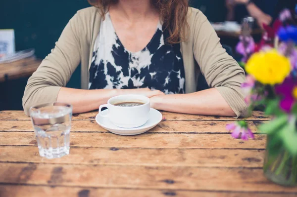若い女性がカフェでのコーヒーのカップを持っていること — ストック写真