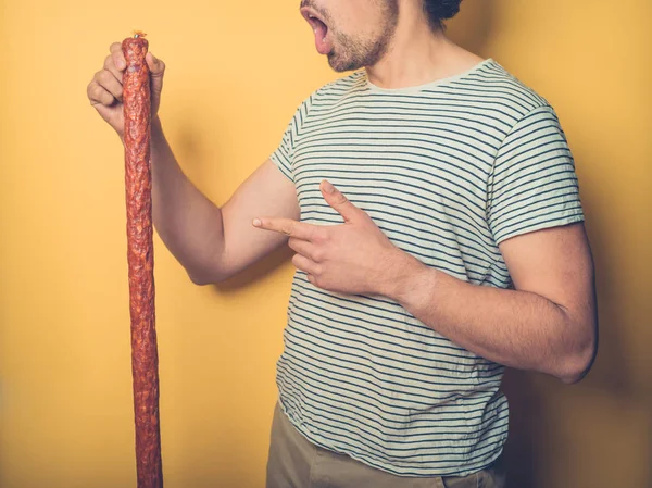 Een Jonge Man Houdt Een Grote Worst Verbaasd Enorme Omvang — Stockfoto