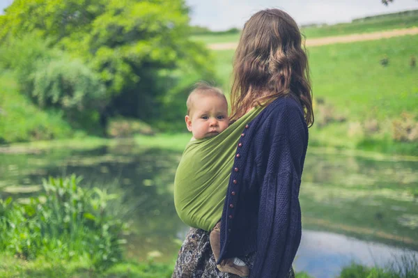 Uma Jovem Mulher Com Bebê Uma Funda Está Lado Uma — Fotografia de Stock