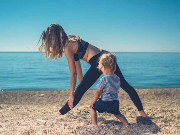 Una Joven Madre Está Haciendo Yoga Playa Con Hijo — Foto de Stock