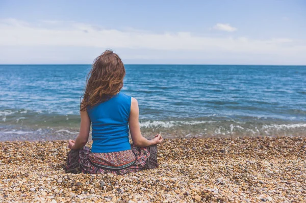 Genç Bir Kadın Sahilde Oturuyor Meditasyon Yapıyor — Stok fotoğraf