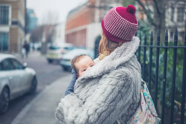 Genç Bir Anne Bebeğini Bir Taşıyıcı Askı Ile Kış Aylarında — Stok fotoğraf