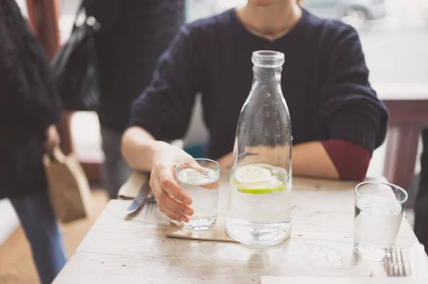 Una Joven Está Sentada Una Mesa Restaurante Está Bebiendo Agua —  Fotos de Stock