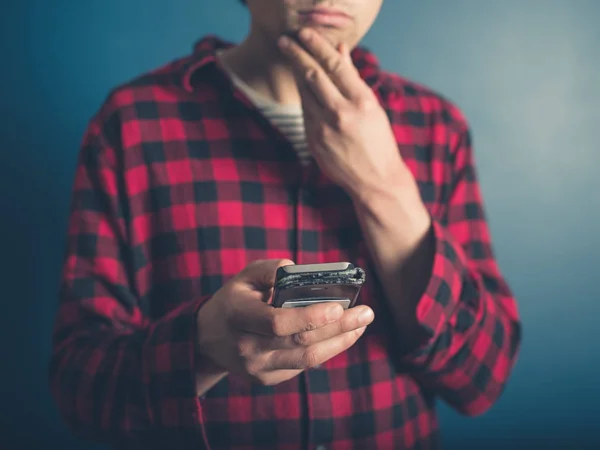 Jovem Hipster Vestindo Uma Camisa Lenhador Está Usando Seu Telefone — Fotografia de Stock