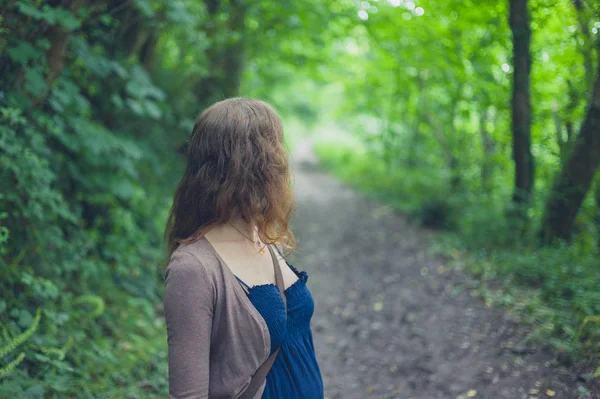 一名年轻女子站在一片森林 — 图库照片