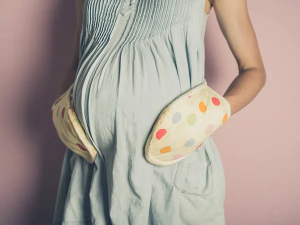 Een Zwangere Vrouw Handschoenen Van Oven Het Aanraken Van Haar — Stockfoto