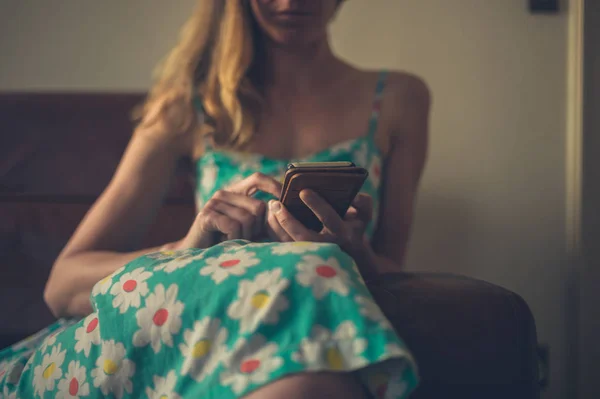 Una Mujer Joven Está Sentada Sofá Casa Está Usando Teléfono — Foto de Stock