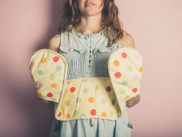 Uma Jovem Está Posando Com Luvas Forno Contra Fundo Rosa — Fotografia de Stock