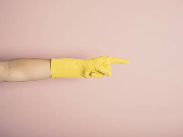 一只戴着黄色橡胶手套的女手指着 — 图库照片