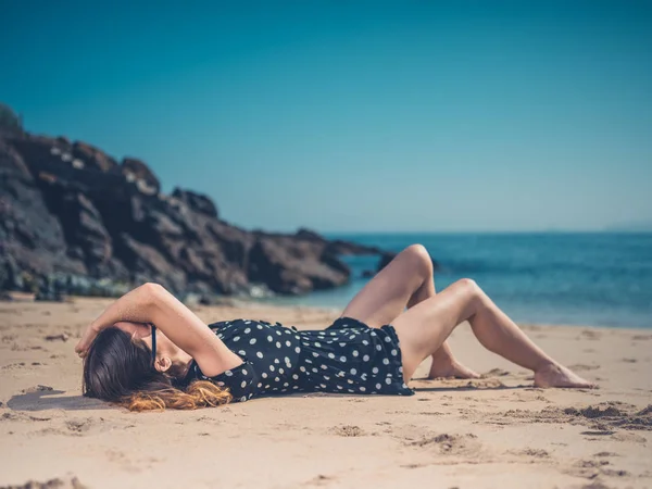 Μια Όμορφη Νεαρή Γυναίκα Είναι Χαλαρώνοντας Στην Παραλία — Φωτογραφία Αρχείου