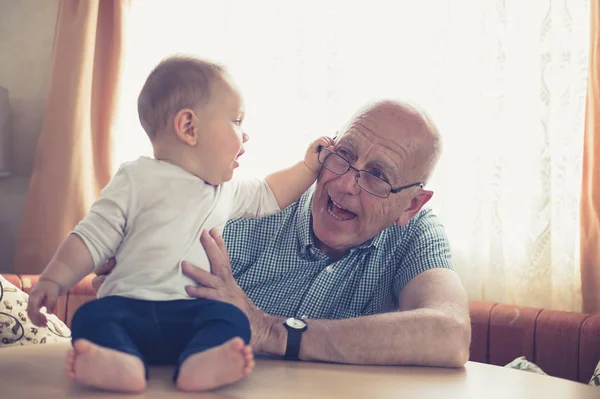 Dziadek Gra Małym Dzieckiem Który Jest Chwytając Jego Okulary — Zdjęcie stockowe