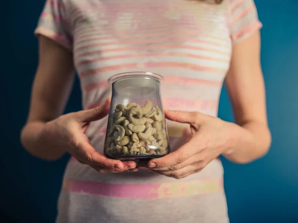 Una Joven Sostiene Frasco Nueces Anacardo — Foto de Stock