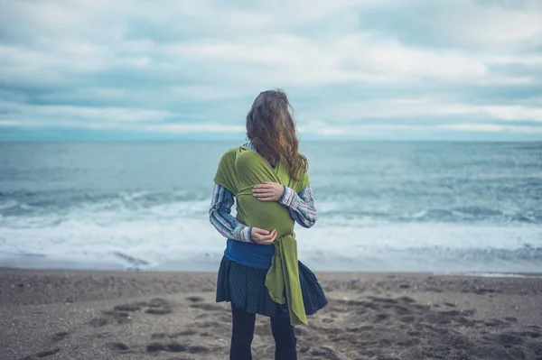 Una Giovane Madre Piedi Sulla Spiaggia Con Suo Bambino Avvolto — Foto Stock