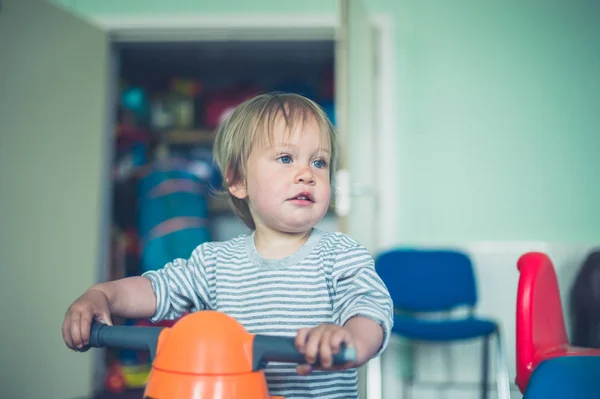 かわいい男の子が屋内で三輪車の Sititng — ストック写真