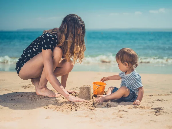 Una Joven Madre Está Jugando Con Hijo Playa Construyendo Castillos — Foto de Stock